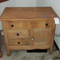 Full front view of wood dresser showing drawers and cabinet door. Visible wear and scratches on surface.