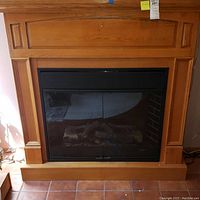 Full frontal view of the electric fireplace with wooden mantel and glass door enclosure.