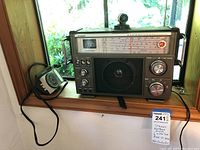 Full frontal view of the Stewart multiband receiver next to the Micornta mechanical timer on a window sill showing the overall condition and size.