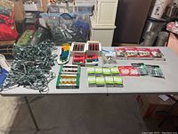 Overview photo of all items on table showing green wired light strands, bulb packs, LED micro light boxes, and clip boxes.