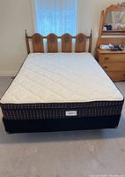 Full front view of queen bed set showing wood headboard, mattress, box spring and metal frame