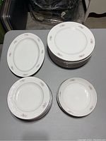 Overview of all dishes on table showing stacks of plates and oval serving plate