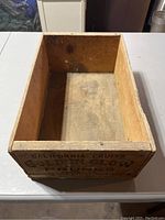 Open top view of vintage wooden fruit crate with text on the side indicating brand and contents