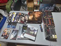 Overview of the collection showing magazines, books, VHS tapes, and calendars on a table.