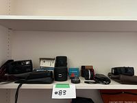 Shelf with multiple 35mm cameras, lenses, adapters, cases