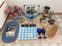 Top view of the lot showing all glass, ceramic, textile items and cookbook.