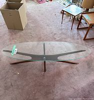 Top-down view of glass tabletop and teak starburst base