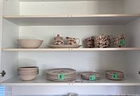Full view of kitchen cabinet shelf holding set of Staffordshire Old Granite patterned dish set items including cups, saucers, bowls, plates, and serving bowl.