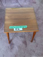Photo of the teak end table top showing wood grain and a green taped ruler with dimensions 17.5"L x 17.5"D x 16"H.
