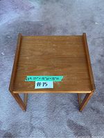 Top view of teak side table showing square top with raised edges and wood grain.