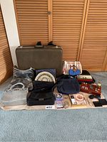 Full overview of the lot showing all purses, jewelry, and accessories arranged on the floor in front of wooden doors.