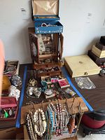 Overview of the assortment of jewelry including multiple bracelets, necklaces, a wall rack, and jewelry boxes.