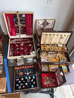 Overview shot of multiple jewelry boxes with assorted costume jewelry including necklaces, pins, and bracelets.