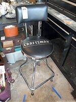 Side view of the Craftsman branded padded seat and backrest stool with chrome frame and footrest.