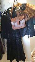 Black velvet dress, brown croc leather purse hanging on hanger, brown velvet jacket
