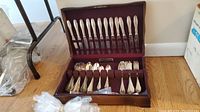 Wooden chest open with flatware displayed