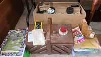 Photo of sewing box with handle surrounded by sewing materials, foliage cards, and boxes of camera equipment