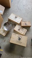 Photo of four Paul Revere Limited Edition cookware boxes and one stainless steel skillet placed on top of one box.