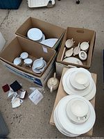 Overview of boxed Lifetime China and Konigl or Tettau China pieces including plates, cups, serving bowls, and other items