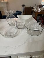 Top image showing assortment of glassware: large flared vase, white opaque bowl, square vase, and textured round bowl.