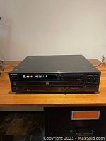 Front view of the Sony 5-disc CD changer showing the digital display active, control buttons, and disc tray