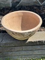 Terracotta planter bowl placed on stone surface with clear view of interior and exterior pattern.