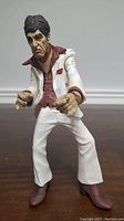 Front view of the 2005 Mezco Scarface Al Pacino talking voice action figure in white suit with red shirt and brown shoes.