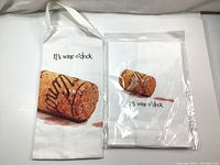 Two canvas wine gift bags and two cotton kitchen towels featuring cork and the phrase 'It's wine o'clock' printed on them. One towel is in original packaging.