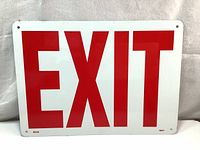 Front of the aluminum EXIT sign showing large red letters on white reflective enamel finish.