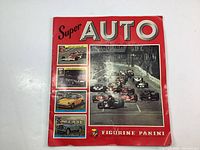 Cover of the 1977 Super Auto Figurine Panini sticker album with images of racing cars and automobiles on a red background.
