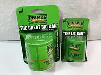 Front view of two new Primos Hunting deer calls, The Great Big Can and The Lil' Can, in their original packaging showing bright green color and branding.