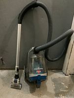 Full view of Bissell PowerForce Turbo PET vacuum cleaner showing hose and handle with vacuum head attachment on floor