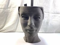 Front view of the layered face puzzle sculpture showing facial features and horizontal layers.