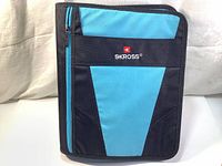 Closed SKROSS student zipper binder showing blue and black color with front zipper pocket and SKROSS logo.