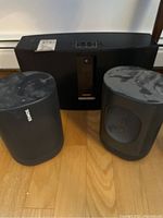 Bose SoundTouch 30 system positioned behind two Sonos One speakers on hardwood floor