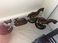 Photo showing four cast iron animal door stoppers including a cat, a rabbit, and two horses in a row