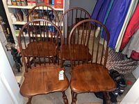 Photo showing three Hitchcock Windsor style chairs with medium brown finish and spindled backs