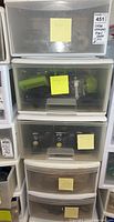Photo showing stacked plastic storage drawers labeled with contents and seller lot number