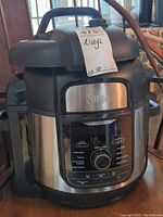 Front view of Ninja Foodi Deluxe Cooker FD402 LP3 model showing the control panel, brand name, and stainless steel exterior.