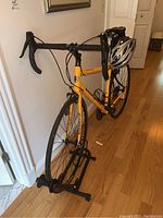 Full left-side view of yellow road bike on trainer stand