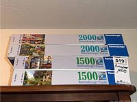 Four Ravensburger puzzle boxes stacked: 2 boxes labeled 2000 pieces, 2 boxes labeled 1500 pieces