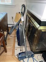 Side view of Kenmore model 116.27112790 vacuum cleaner standing upright with attached hose and metal wand.