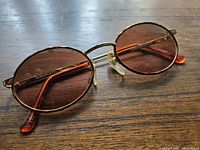Front view of vintage Serengeti sunglasses showing brown tinted lenses in gold metal frame with tortoiseshell arms