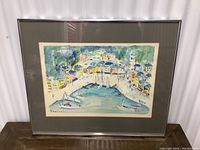 Framed signed print showing colorful Portofino Italy harbor scene, angled view