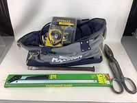 Full view of Mastercraft Maxtrim tool bag with contents including metal nail, vintage scissors, and folding saw in packaging.