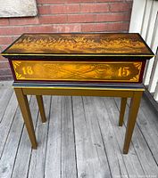 Front view of stand showing dated 1815 with crossed swords motif and painted military scene on lid
