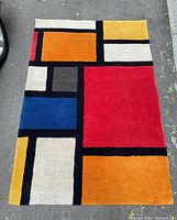 Flat lay of full rug on pavement showing color block design