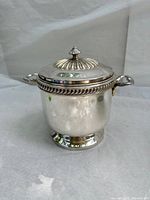 Full front and side view of vintage EPNS silverplated ice bucket with handles and lid on a white background.