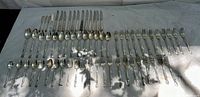 Full set of vintage Rogers Bros. EPNS flatware laid out on a fabric surface, showing a variety of spoons, forks, and knives in rows.