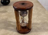 Photo of a 7-inch handcrafted hourglass showing wooden base and columns with glass bulbs containing sand